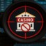 Casino building in crosshair with prohibition symbol representing gambling enforcement crackdown