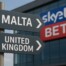 Directional signs showing Malta and United Kingdom with SkyBet logo representing gambling operator's relocation from UK to Malta