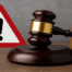 A judge’s gavel beside a warning symbol representing the UKGC’s £10 million fine issued to Platinum Gaming, operator of Unibet, in 2025.