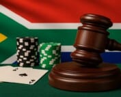 South African flag with judge's gavel, casino chips, and playing cards representing proposed 20% online gambling tax