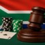 South African flag with judge's gavel, casino chips, and playing cards representing proposed 20% online gambling tax
