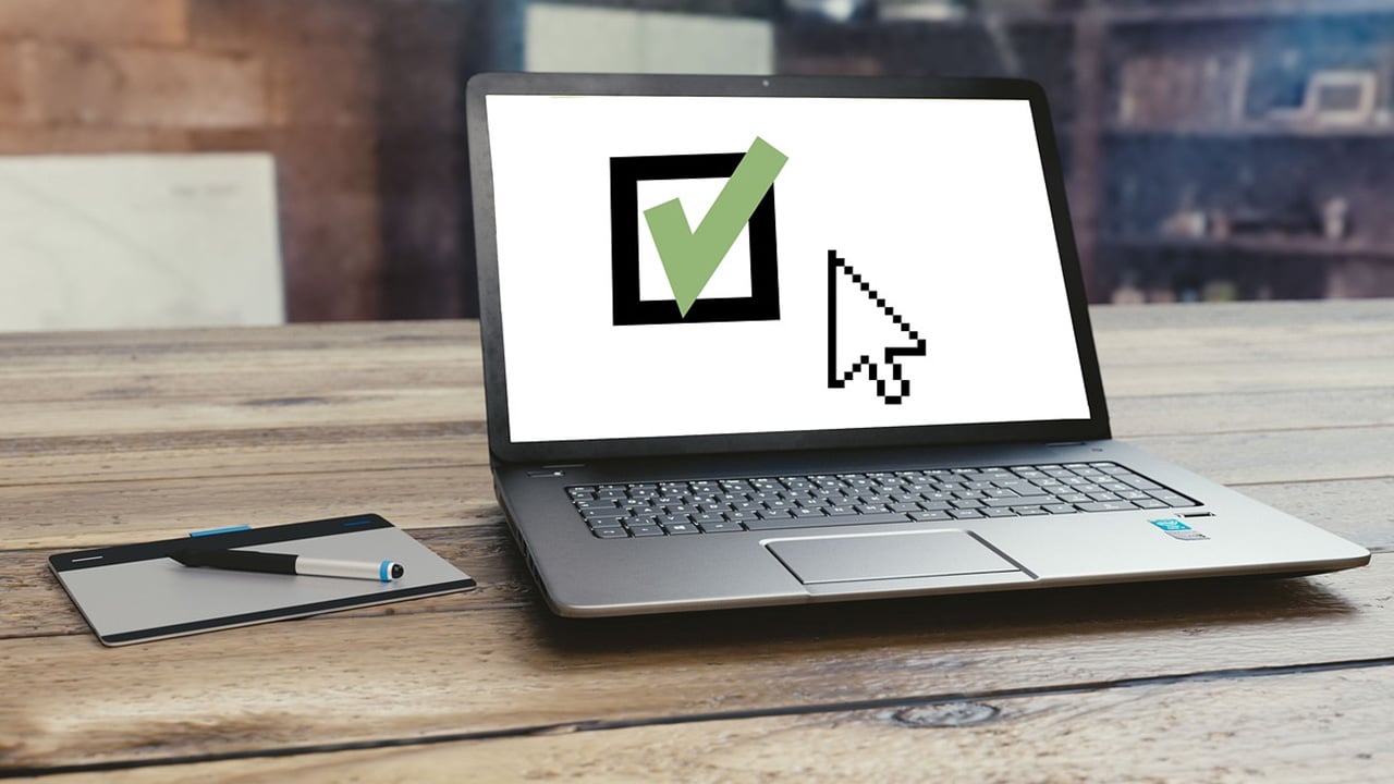 Ein gr&uuml;ner Haken auf Laptop Desktop